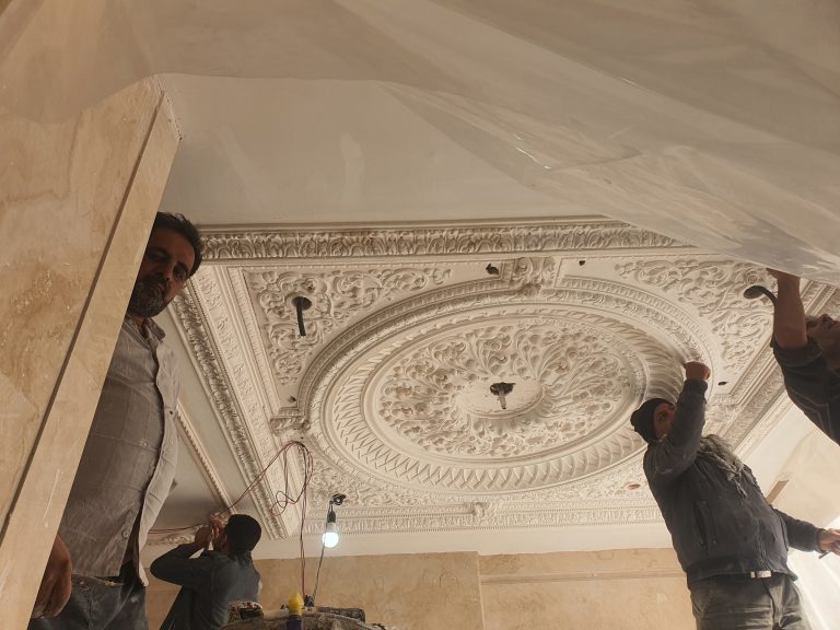 Master craftsman executing a complex Persian stucco relief for a luxury residential project - Motifi Stucco.`